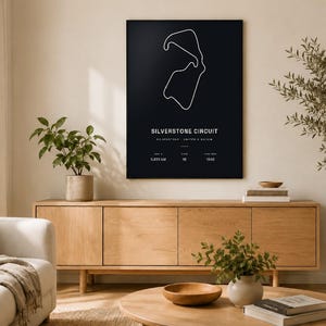 May include: A black rectangular wall art print featuring a white line drawing of the Silverstone Circuit. The text reads Silverstone Circuit, United Kingdom, 5.891 km, 18, 1948. The design is minimalist with white typography on a dark background.