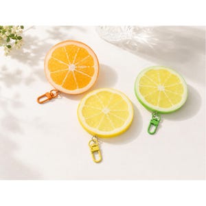 May include: Three circular coin pouches shaped like fruit slices. One orange slice pouch with an orange clip, one yellow lemon slice pouch with a yellow clip, and one green lime slice pouch with a green clip. Each pouch features a realistic citrus print.
