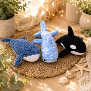May include: Three crocheted sea creatures including a dark blue whale with a white belly, a light blue whale shark with white spots, and a black and white orca. Each plush toy features a textured yarn finish and small black bead eyes.