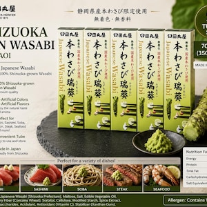 以下が含まれることがあります： 静岡本わさびのチューブ5本セット。各70g、合計350g。パッケージは薄緑色で、黒い日本語の文字とわさびの根や寿司のイラストが描かれています。小さな黒い皿には、緑色のわさびペーストが盛られています。