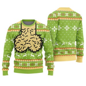 May include: A long-sleeved crew neck jumper in bright green featuring a yellow and red geometric pattern, white snowflakes, and white reindeer silhouettes. The front displays a large, beige, textured graphic with black outlines.