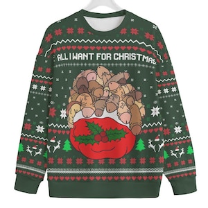 May include: A dark green long-sleeve sweatshirt featuring a repeating white and red holiday pattern of hearts, snowflakes, and reindeer. The centre graphic shows a red sack overflowing with phallic shapes and the text ALL I WANT FOR CHRISTMAS.