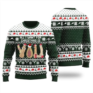 May include: A dark green long-sleeve jumper featuring a white knit pattern of Santa hats, snowflakes, and sperm cells. The front displays the text ALL I WANT FOR CHRISTMAS IS YOU, with the letters spelled out using graphic illustrations of genitalia.