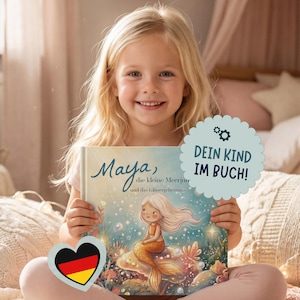Könnte beinhalten: Ein gebundenes Kinderbuch mit dem Titel Maya, die kleine Meerjungfrau und das Glitzergeheimnis, das eine blonde Meerjungfrau auf einem Korallenriff zeigt. Ein hellblauer, gewellter Aufkleber trägt den Text DEIN KIND IM BUCH.