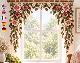May include: A crochet window valance featuring large pink and mauve flowers, small white blossoms, and dark green leaves. The floral arrangement is suspended from a wooden rod with loops, creating a decorative border across the top of the window.