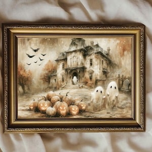 May include: A rectangular gold-toned frame containing a print of a haunted mansion scene. The artwork features a large house, several glowing jack-o'-lanterns in the foreground, two small white ghosts, and a flock of black bats in the sky.