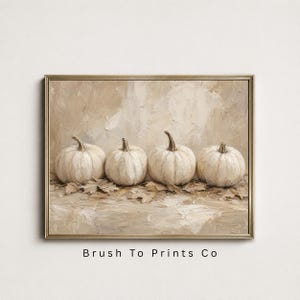 May include: An oil painting print in a gold frame featuring four white pumpkins arranged in a row on a bed of dried leaves. The artwork uses thick, textured brushstrokes in neutral beige and cream tones. The text Brush To Prints Co is visible.
