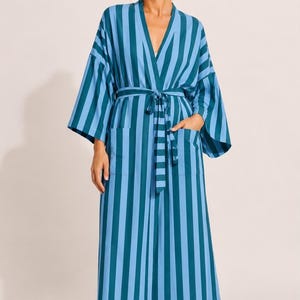 以下が含まれることがあります： ティールブルーとライトブルーの交互の縦縞模様が特徴の、ふくらはぎ丈のローブ。ゆったりとした着物スタイルの袖、ウエスト部分の共布の結びベルト、そして前面に2つの大きなパッチポケットが付いたデザインです。