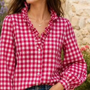 Blusa rosa de algodón con volantes y mangas abullonadas, con botones.