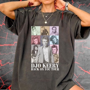 May include: A charcoal gray short-sleeve t-shirt featuring a grid of nine photographic portraits of a person in various poses and outfits. Below the grid, the white text reads "DJO KEERY BACK ON YOU TOUR" in a bold, capitalized sans-serif font.