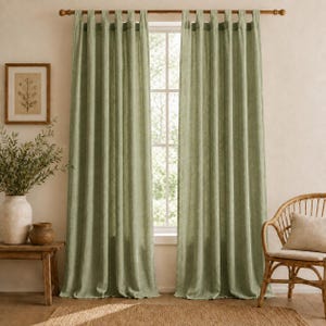 Peut inclure: Une paire de rideaux vert sauge tombant jusqu'au sol avec une tête à pattes. Les rideaux sont fabriqués dans un tissu texturé et sont suspendus à une tringle en bois, couvrant une fenêtre qui laisse passer la lumière naturelle.