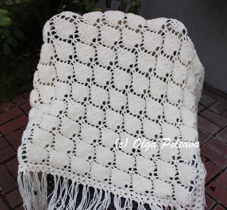 May include: A white crocheted throw blanket with a fringe border. The blanket has a repeating pattern of small circles. The text (c) Olga Poltava is visible in the lower right corner of the image.