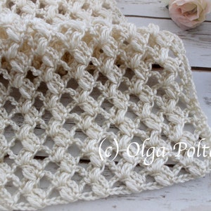 May include: A cream-coloured, hand-crocheted scarf with a delicate openwork pattern. The scarf features a repeating floral-like design and a textured, three-dimensional effect. The image includes the text "(c) Olga Poltava".