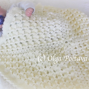 Pode incluir: Um cobertor de beb&eacute; branco de croch&ecirc; com um padr&atilde;o floral delicado. O cobertor &eacute; feito com um fio macio e &eacute; perfeito para manter um beb&eacute; quente e confort&aacute;vel.