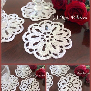 May include: Four white crocheted doilies with a floral design. The doilies are on a wooden surface with red roses in the background. (c) Olga Poltava