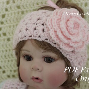 May include: A pink crocheted headband with a large flower accent. The headband is worn by a doll with brown hair and blue eyes. The text "PDF Pattern Only" is visible in the image.