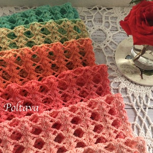 Pode incluir: Uma pilha de faixas de cabelo de croch&ecirc; feitas &agrave; m&atilde;o em tons de verde, p&ecirc;ssego e rosa. As faixas est&atilde;o dispostas sobre uma toalha de croch&ecirc; branca. Um pequeno vaso com rosas vermelhas &agrave; direita.