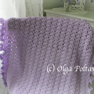 May include: A lavender crochet baby blanket with a delicate lace border. The blanket is draped over a white dresser with a floral arrangement on top. (c) Olga Poltava