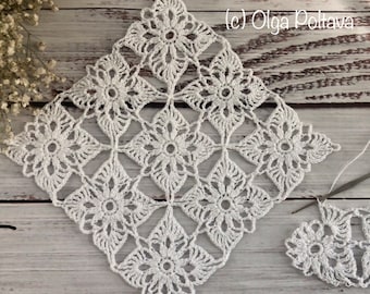 May include: A white, square crochet doily with a floral pattern. The doily is made of white yarn and features a repeating design of flowers and diamond shapes. A smaller, unfinished piece and a crochet hook are visible.
