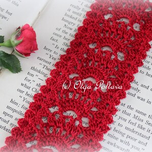 May include: A close-up of a red crocheted bookmark with a delicate floral pattern. The bookmark is lying on a book with text that reads "(c) Olga Poltava".
