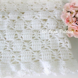 May include: A white crocheted blanket with a detailed openwork pattern. The blanket has a scalloped edge and is next to a bouquet of pink roses. The text "(c) Olga Poltava" is visible.