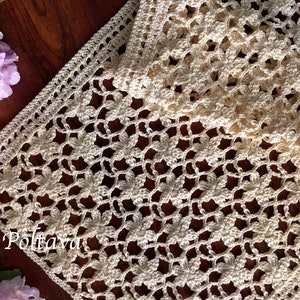 May include: A crocheted table runner with a delicate floral pattern in a cream color. The runner is made with a fine yarn and has a delicate, lacy look. (c) Olga Poltaeva
