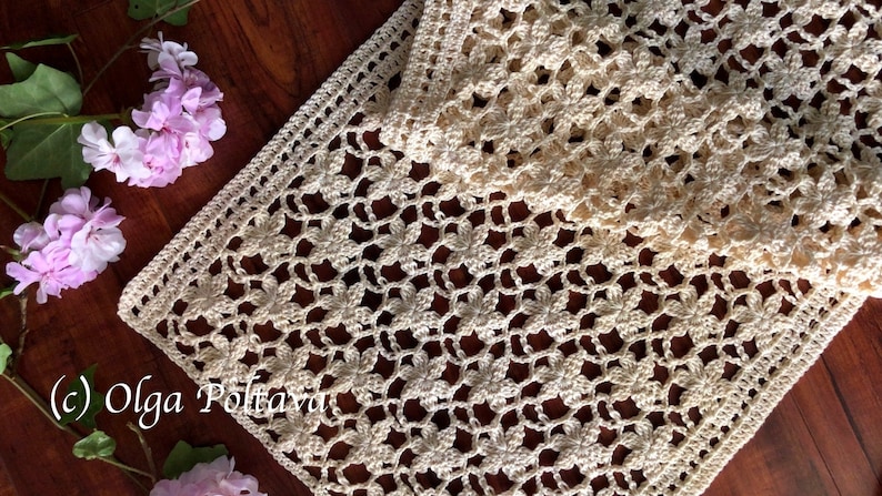 May include: A crocheted table runner with a delicate floral pattern in a cream color. The runner is made with a fine yarn and has a delicate, lacy look. (c) Olga Poltaeva