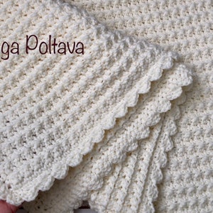 Puede incluir: Una manta de ganchillo blanca con un borde festoneado. La manta est&aacute; doblada por la mitad y el texto (c) Olga Poltava es visible.