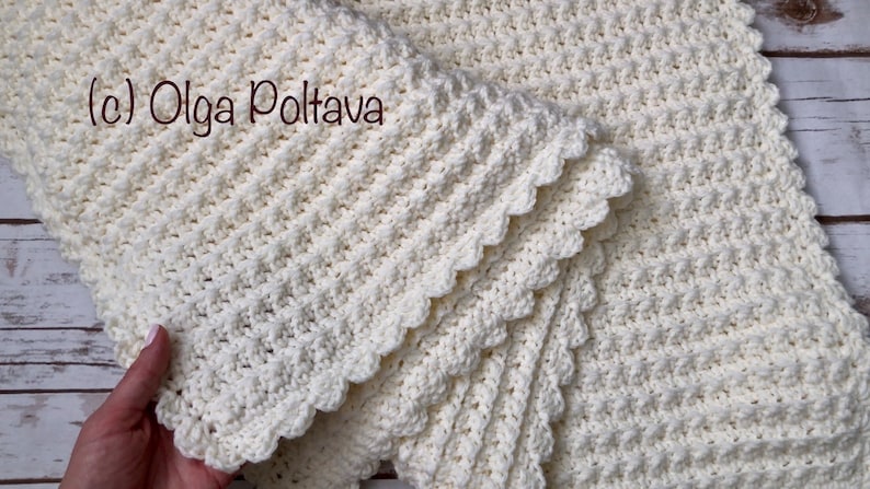 Puede incluir: Una manta de ganchillo blanca con un borde festoneado. La manta est&aacute; doblada por la mitad y el texto (c) Olga Poltava es visible.