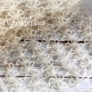 May include: A white crocheted shawl with a delicate floral pattern. The shawl is made of a soft, lightweight yarn and has a flowing, ethereal look.  (c) Olga Poltava