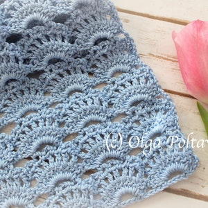 May include: A light blue crocheted fabric with a repeating pattern of scallops. The fabric is laid on a white wooden surface with a pink tulip in the background. The text (c) Olga Poltava is visible in the lower right corner of the image.