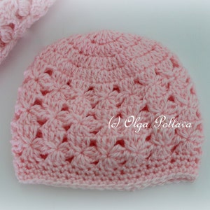 May include: A pink crocheted hat with a flower pattern. The hat is made with a soft yarn and has a comfortable fit.