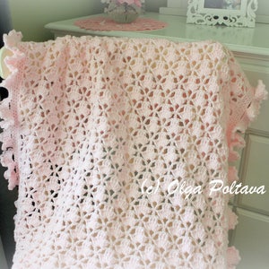 May include: A pink crocheted baby blanket with a delicate floral pattern and a scalloped edge.
