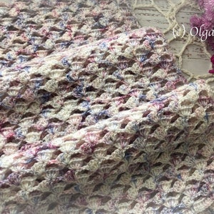Pu&ograve; includere: Uno scialle all'uncinetto in uno schema di colori bianco, rosa e blu. Lo scialle &egrave; realizzato con un punto delicato e traforato e ha una texture morbida e fluida.