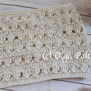 May include: A cream-colored crochet cowl featuring a repeating textured pattern of vertical stitches and horizontal crossed yarn details. The fabric has a consistent openwork design throughout, with the text (c) Olga Poltava visible on the surface.