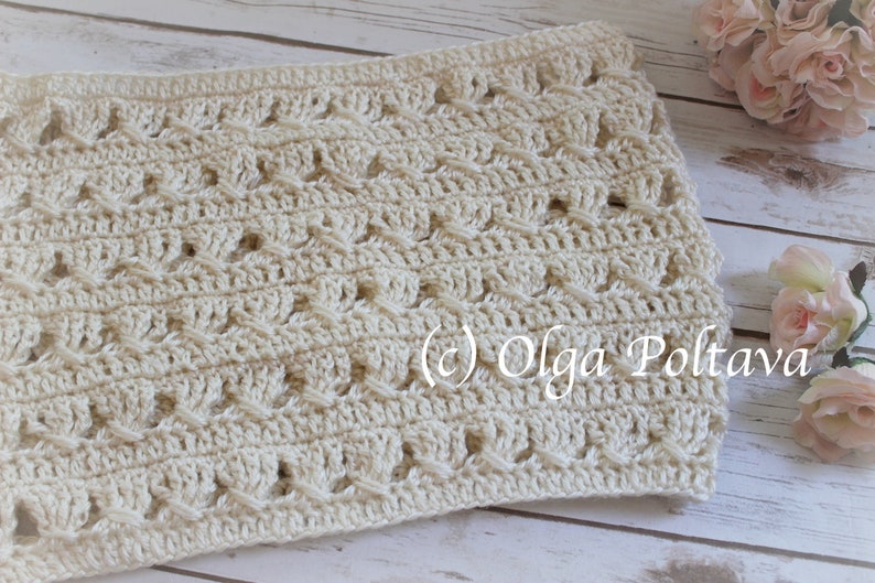 May include: A cream-colored crochet cowl featuring a repeating textured pattern of vertical stitches and horizontal crossed yarn details. The fabric has a consistent openwork design throughout, with the text (c) Olga Poltava visible on the surface.