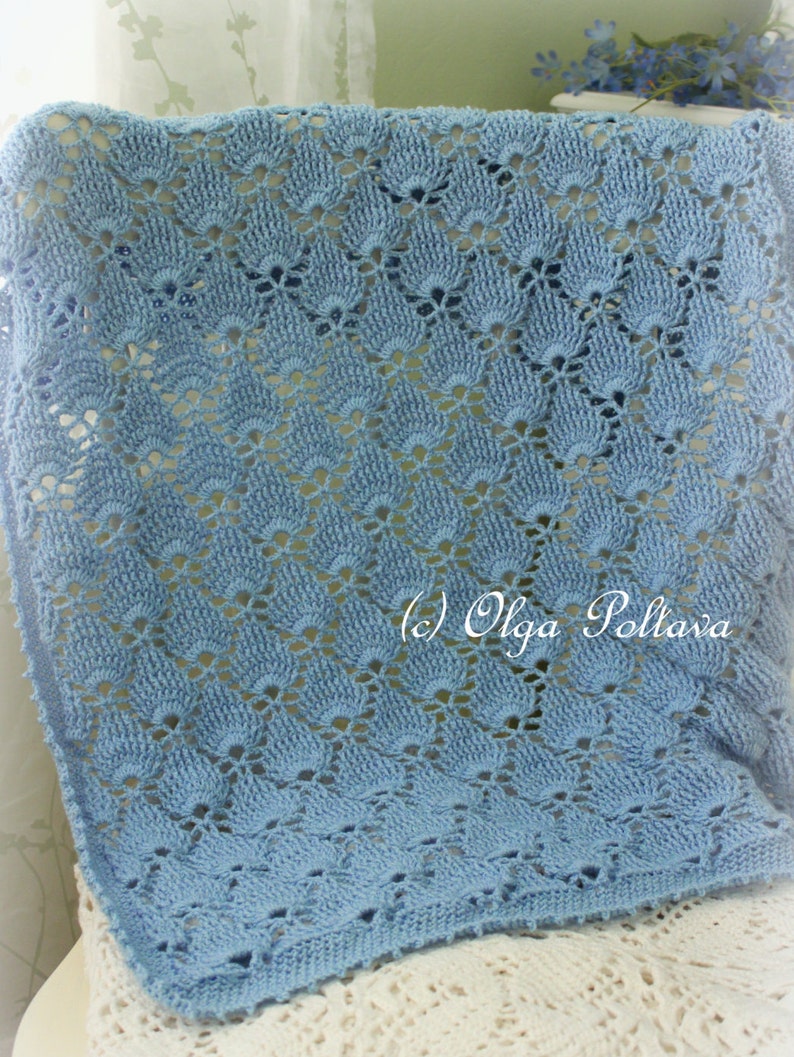 May include: A light blue crocheted baby blanket with a delicate floral pattern. The blanket is made with a fine yarn and has a soft, airy texture. (c) Olga Poltava