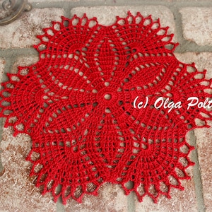 Może przedstawiać: Czerwona koronka szydełkowa o delikatnym, skomplikowanym wzorze. Koronka jest okrągła i ma falowany brzeg. (c) Olga Poltava