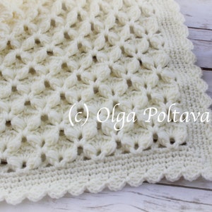May include: A white crocheted baby blanket with a delicate floral pattern and a scalloped border. The blanket is made with soft yarn and is perfect for a newborn baby.
