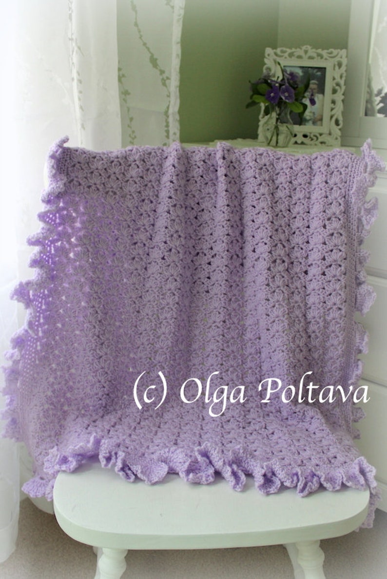May include: A lavender crocheted baby blanket with a ruffled edge. The blanket is draped over a white chair. (c) Olga Poltava