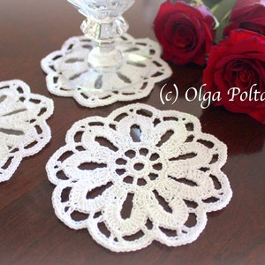 May include: Three white crocheted doilies on a wooden table with red roses. (c) Olga Poltava