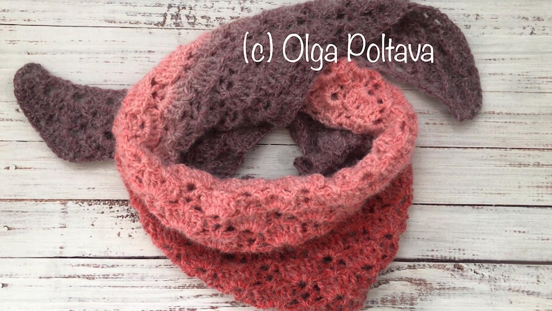 May include: A crocheted cowl in shades of pink and brown with a lacy pattern. The cowl is folded in half and the ends are overlapping. The text (c) Olga Poltava is visible on the cowl.