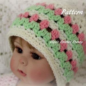 Puede incluir: Un gorro de beb&eacute; de ganchillo en crema, verde y rosa. El gorro presenta un dise&ntilde;o de granny square con el texto "Pattern Only" y "Olga's Crochet Frenzy". El gorro es para beb&eacute;s y ni&ntilde;os peque&ntilde;os.