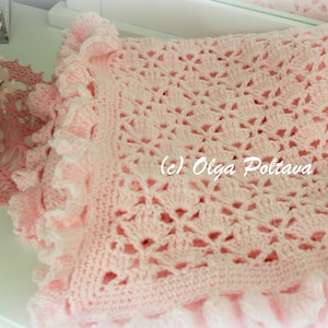 May include: A pink crocheted baby blanket with a delicate lace pattern and ruffled edges. The blanket is made with soft yarn and has a delicate, feminine look.