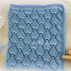 May include: A light blue crocheted baby blanket with a delicate, lacy pattern. The blanket is made with a soft yarn and has a scalloped edge.