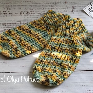 May include: A pair of crocheted socks in a green, yellow, and brown color scheme. The socks are hand-knitted and have a textured pattern.