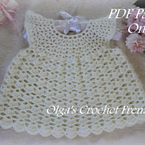 May include: White crochet baby dress with a scalloped hem. The dress has a simple design with a round neckline and sleeveless style. The text "PDF Pattern Only" and "Olga's Crochet Frenzy" is visible in the image.