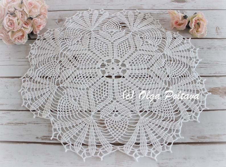 May include: White crocheted doily with a delicate floral pattern. The doily is circular and has a diameter of approximately 12 inches.