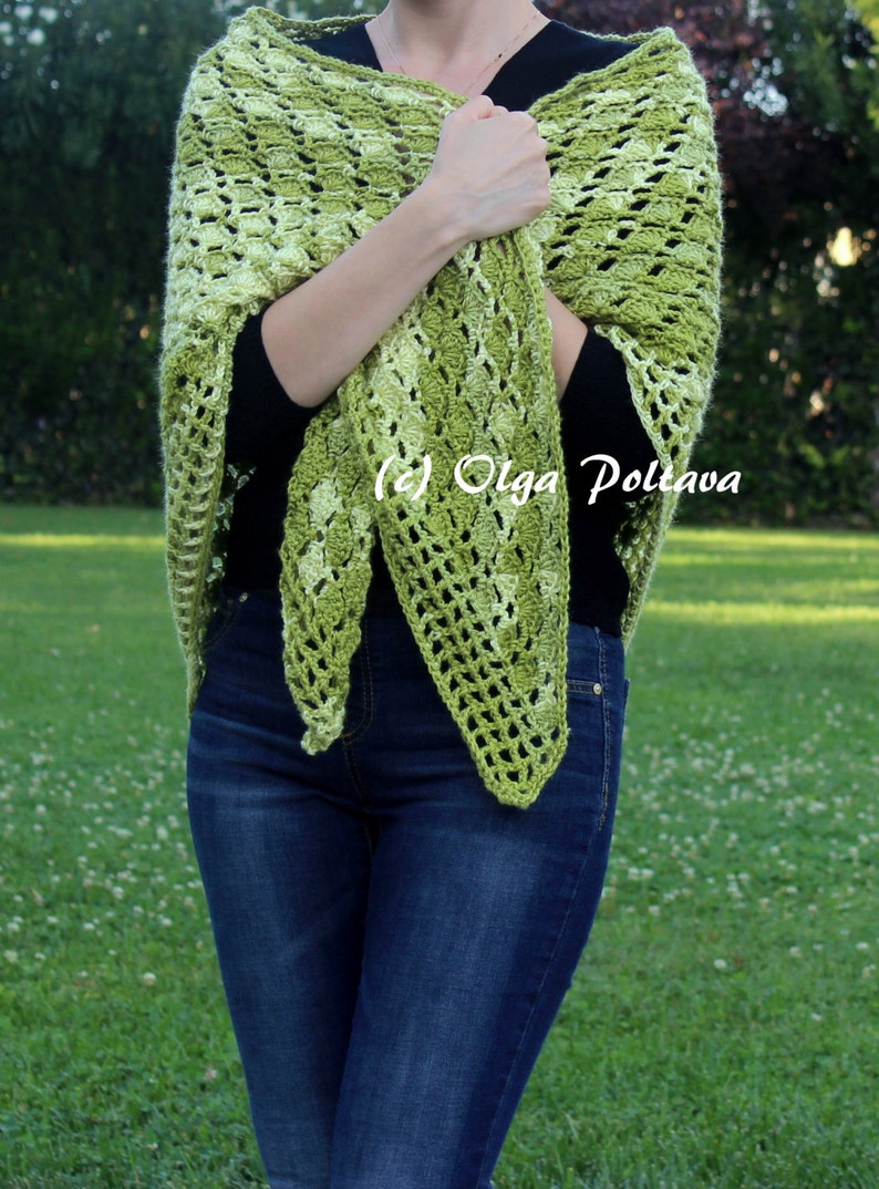 May include: A triangular crochet shawl featuring a variegated pattern of light and dark green yarn. The openwork design displays a repeating textured stitch pattern throughout the fabric. The text (c) Olga Poltava is visible on the shawl.