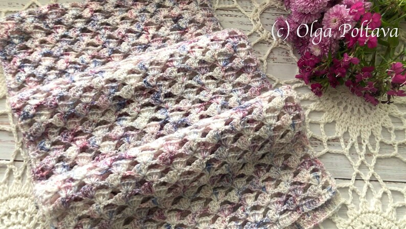 Pu&ograve; includere: Uno scialle all'uncinetto bianco con accenti rosa e blu. Lo scialle &egrave; realizzato con un delicato punto a maglia e ha una sensazione morbida e ariosa.